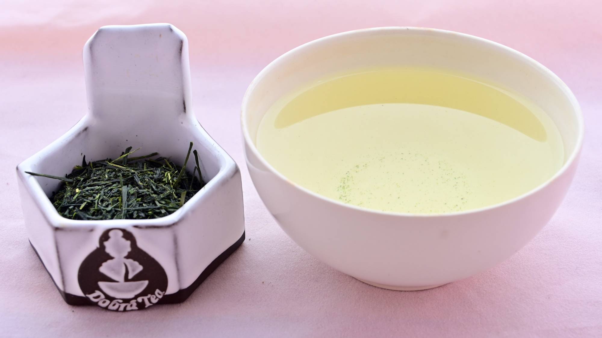 A side-by-side comparison of Kabusecha leaves and steeped tea. On the left, the leaves are long, thin and needle-like with a dark-green color. On the right, the steeped tea is a pale green.