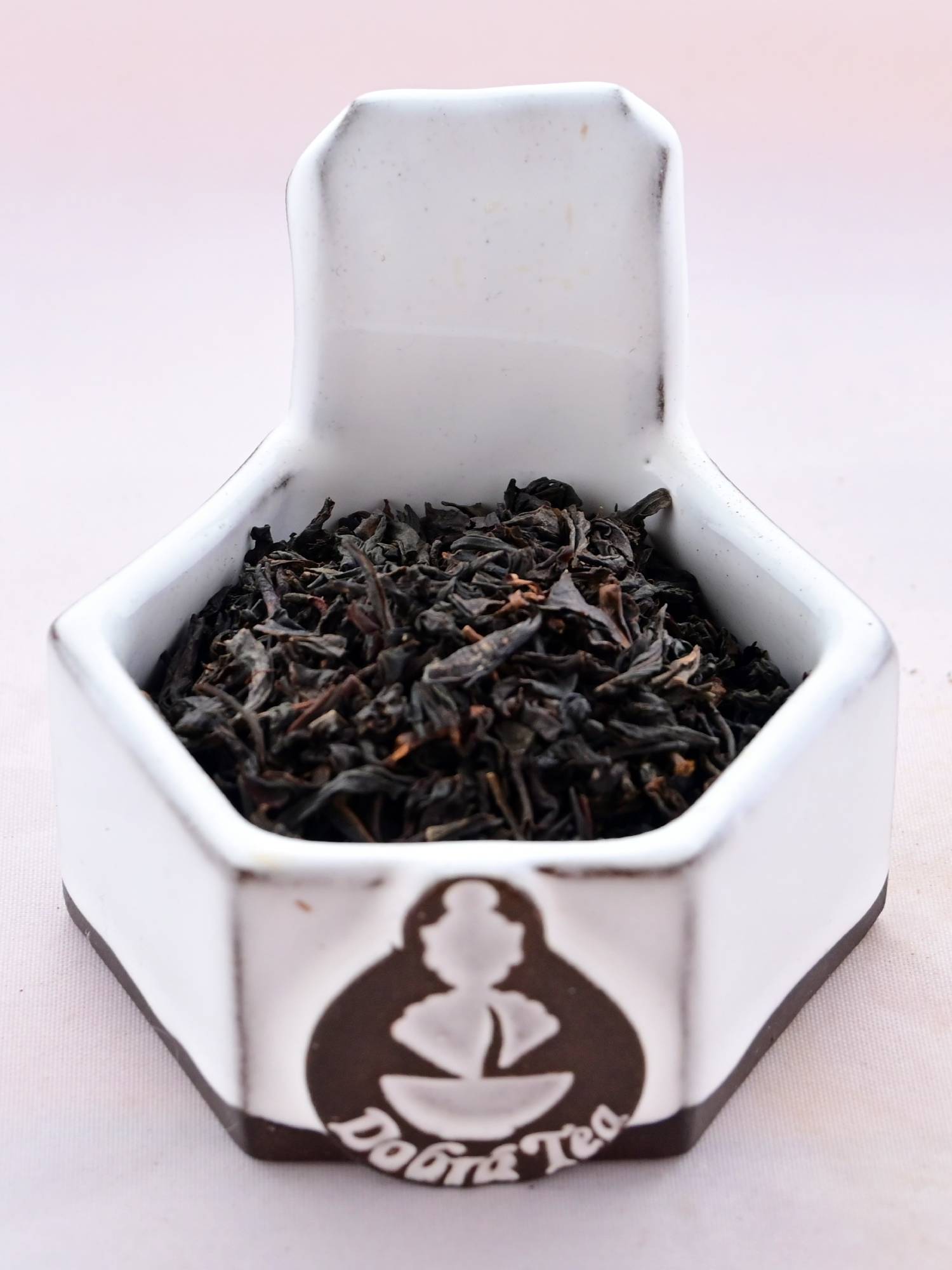 A close-up of Vanilla Tea leaves. The leaves are black, and slightly broken, making them smaller and less curled than other black teas.