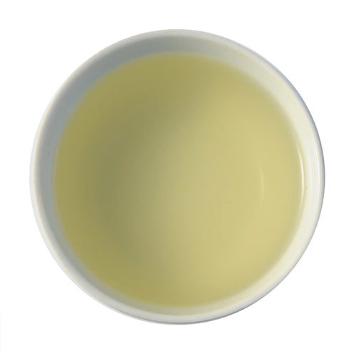 A close-up of steeped Bi Luo Chun tea. The tea is a soft green-yellow color.