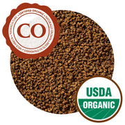 A close-up of CTC tea pellets, which are small, round, and uniform. They are all a light brown color. They have Certified Organic and USDA Organic certifications.