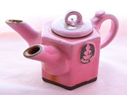The dual-spouted Casanova rose tea pot is hexagonal and pink in color, with a Dobra Tea logo of exposed brown clay on the side.