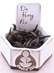 A close-up of Da Hong Pao leaves. The leaves are long and thick, with a slight curl around the edges. They range in color from dark brown to black.