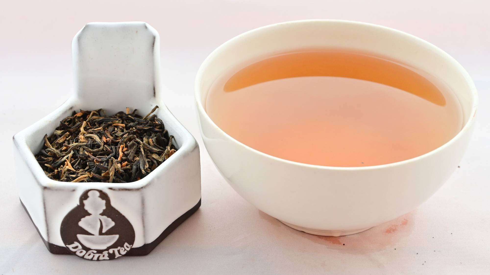 A side-by-side comparison of Dian Hong leaves and steeped tea. On the left, the leaves are small and range from light brown to dark brown in color. On the right, the steeped tea is a rich orange.