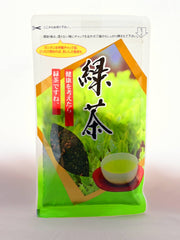 The Genmaicha package is a plastic, re-seal-able package. It is green and white, and prominently features Japanese kanji with instructions on where to open the package. It shows pictures of a cup of green tea and a tea bush. It also have a clear window to show the tea leaves inside.