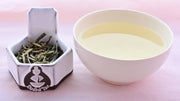 A side-by-side comparison of Huang Ya leaves and steeped tea. On the left, the leaves are long and thick, resembling dried yellow buds more than traditional leaves. On the right, the steeped tea is a pale yellow.