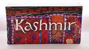 The paper Taste of Kashmir box features intricate designs and decorations, as though someone hand-embriodered a red and brown blanket with orange, green, purple, blue and other threads. White text reads: "Kashmir."