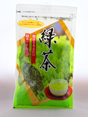 The plastic Kukicha packet prominently features a picture of a growing, green tea bush framed by a diamond in gold. There is a clear spot in the package that shows the stems inside, There are Japanese letters explaining the opening process and resealable nature of the package, as well as the name.