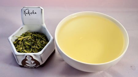 A side-by-side comparison of Kukicha leaves and steeped tea. On the left, the tea is a mix of stems and leaves that have been lightly processed, and range in color from light green to vibrant green. On the right, the steeped liquid is a warm yellow.