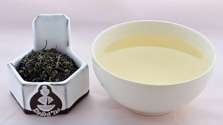 A side-by-side comparison of Mao Jian leaves and steeped tea. On the left, the leaves appear small, twisted, and dark green. On the right, the steeped liquid is pale yellow.