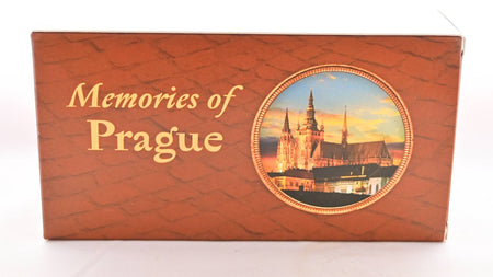 The Memories of Prague paper box is brick-red with a shingled pattern across it. Inside a circle toward the right, a magnificent cathedral is featured against a sunset. Text reads: "Memories of Prague."