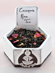 A close-up of Casanova Rose Tea leaves. The leaves are a ninety-ten blend of black tea and rose petals. The black tea leaves are tightly spiraled and slightly broken. 
