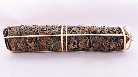 The Sa Bang tea comes in a cigar-shaped tube, with tea leaves packed into cylindrical nuggets and tied together loosely with a pale twine. The leaves themselves range in color from light brown to black.