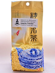 The Tung Ting package is predominantly gold, with an ornate blue teapot on the bottom portion. The top two thirds of the packet is smooth, and the bottom third bulges out indicative of vacuum-sealing around the pebble-shaped leaves. There is a Dobra identification sticker on it, obscuring some Chinese lettering.