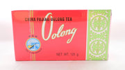 The Wu Long Cha box is rectangular and wrapped in clear plastic. Beneath is a predominantly red box with green detailing on the right side. Text reads: "China Fujian Oolong Tea. Xiamen Tea Import and Export Company. Sea Dyke Brand." There are also Chinese letters of the brand and company name.